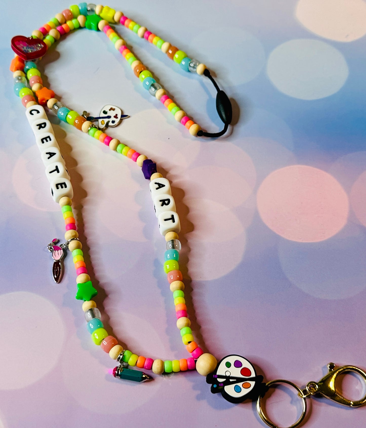 Colorful letter beads spelling CREATE ART on the handmade art teacher lanyard