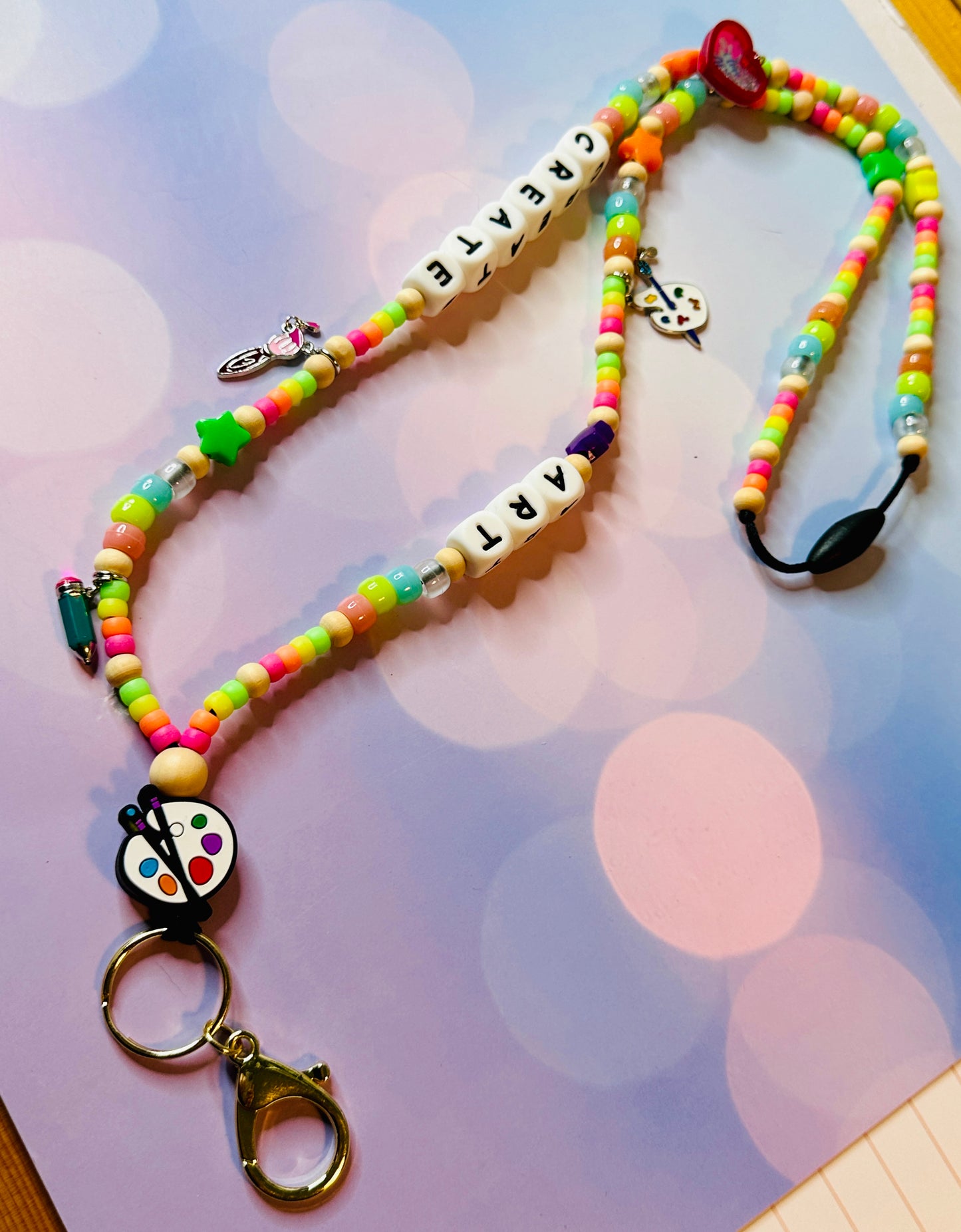 Close-up view of the breakaway safety clasp on the art teacher lanyard for secure badge and key holding