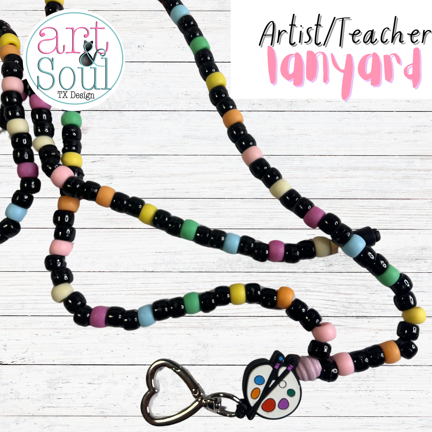 Close-up view of artist lanyard showing adorable paint palette silicon charm and heart-shaped safety breakaway clasp for classroom use.