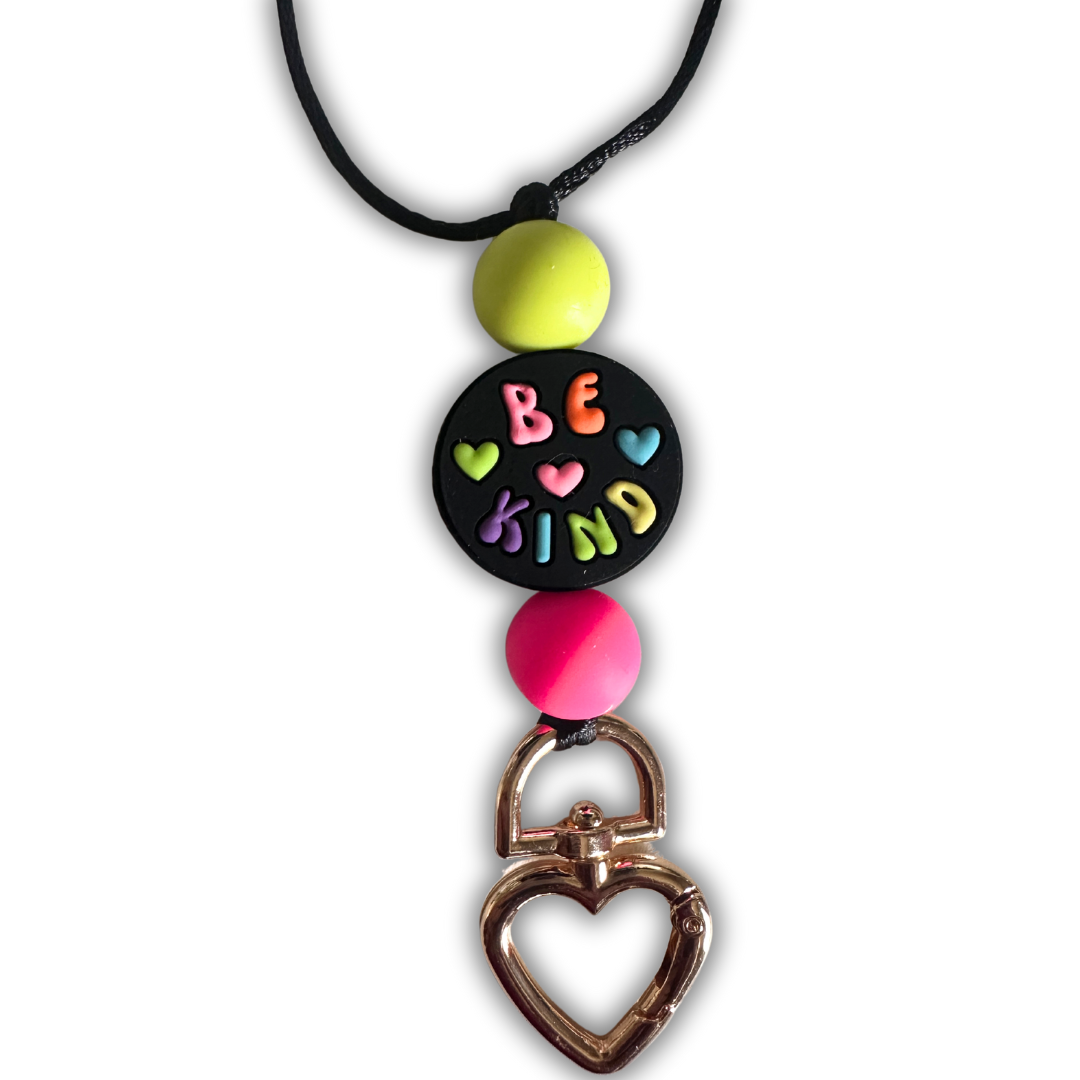 Detailed view of rainbow-colored Be Kind lanyard highlighting sturdy heart-shaped clasp for secure key holding and safety breakaway clasp for teacher protection.