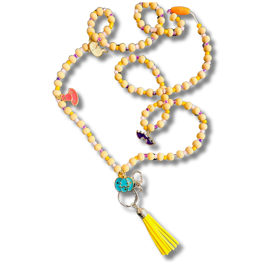 A Halloween-themed lanyard featuring wooden beads, a colorful tassel, and charms including a pumpkin, bat, witch hat, and ghost.