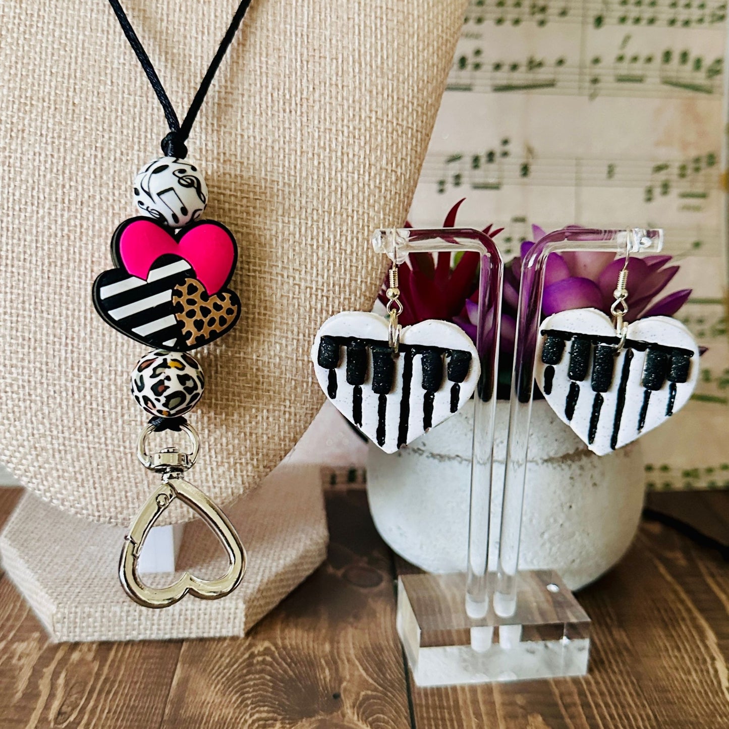 A close up of the Music teacher accessories on a table surface with a plant behind it and a musical note background.