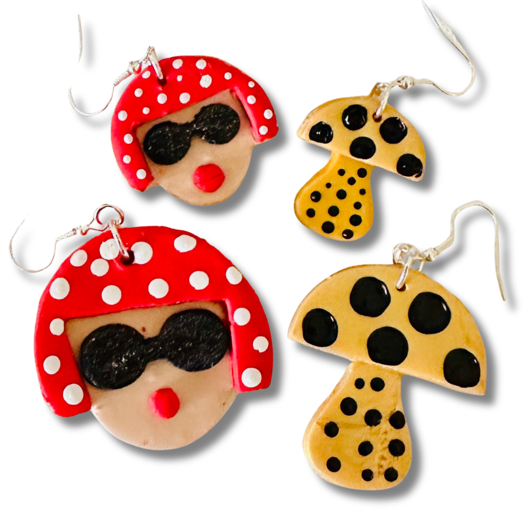 Size comparison of Yayoi Kusama polymer clay earrings showing large and small variants with portrait, red polka dot hair, and yellow mushroom on white background.