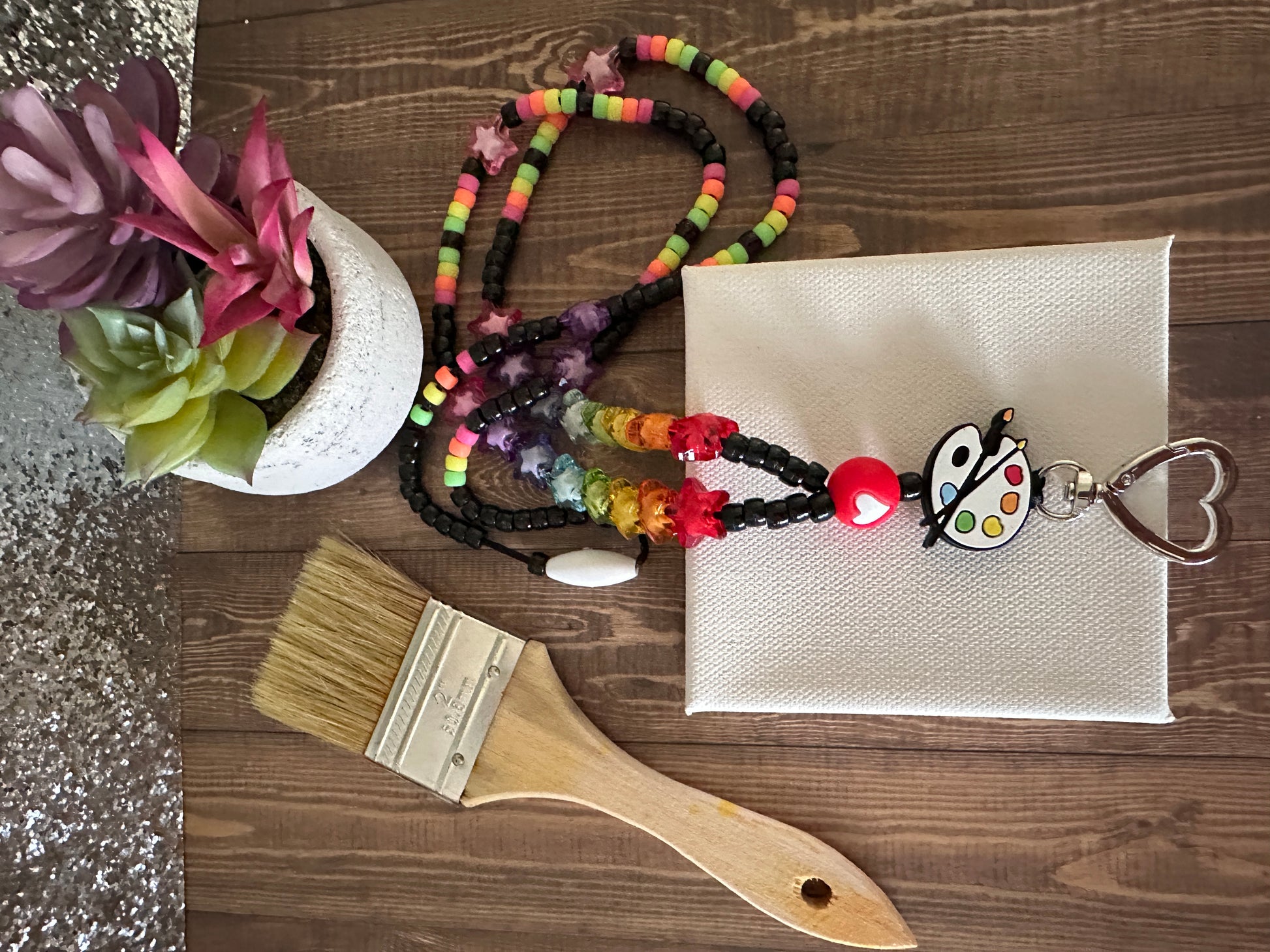 Alternative angle of art teacher lanyard with canvas and art supplies for educators.