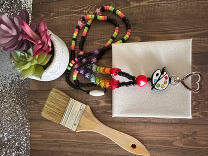 Alternative angle of art teacher lanyard with canvas and art supplies for educators.