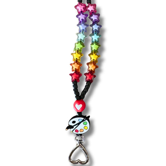 Art teacher lanyard showing off its colorful star-shaped beaded lanyard with a heart-shaped keychain  and paint palette silicone bead on a white background