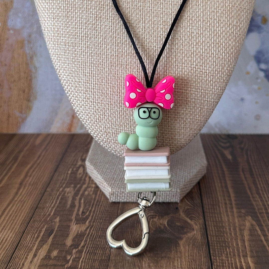 A very close up of the book worm lanyard  on a mannequin bust resting on a wooden surface.