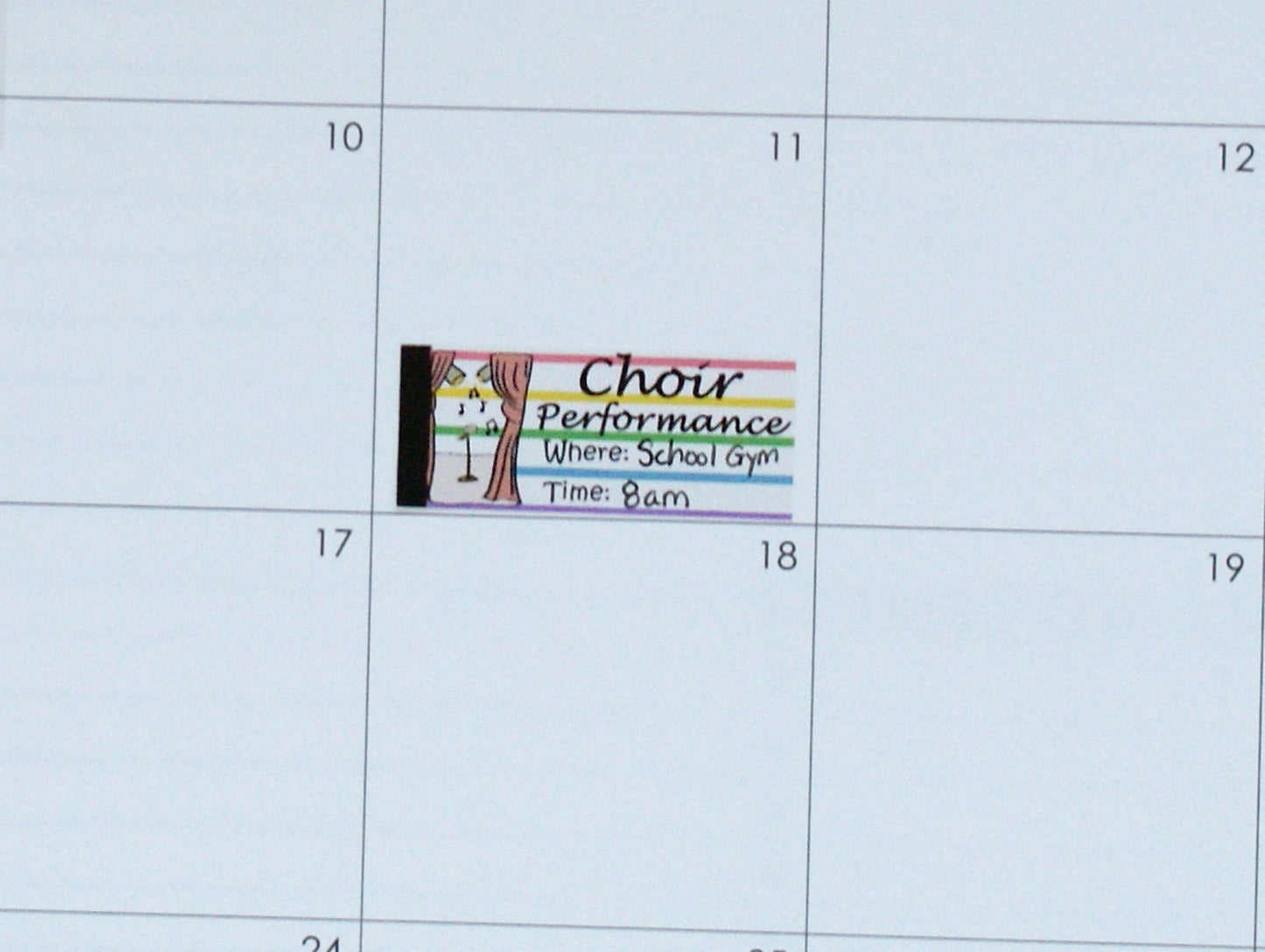 Close up of choir performance reminder sticker placed in music teacher planner for concert date and location tracking.