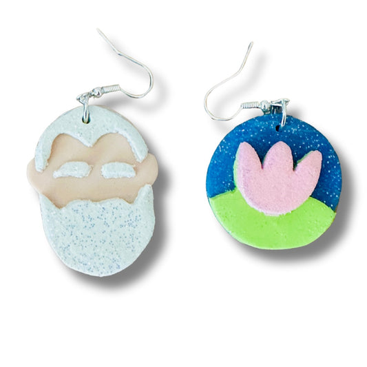 Handmade Claude Monet earrings close up showing white beard portrait design and vibrant water lily on white background.
