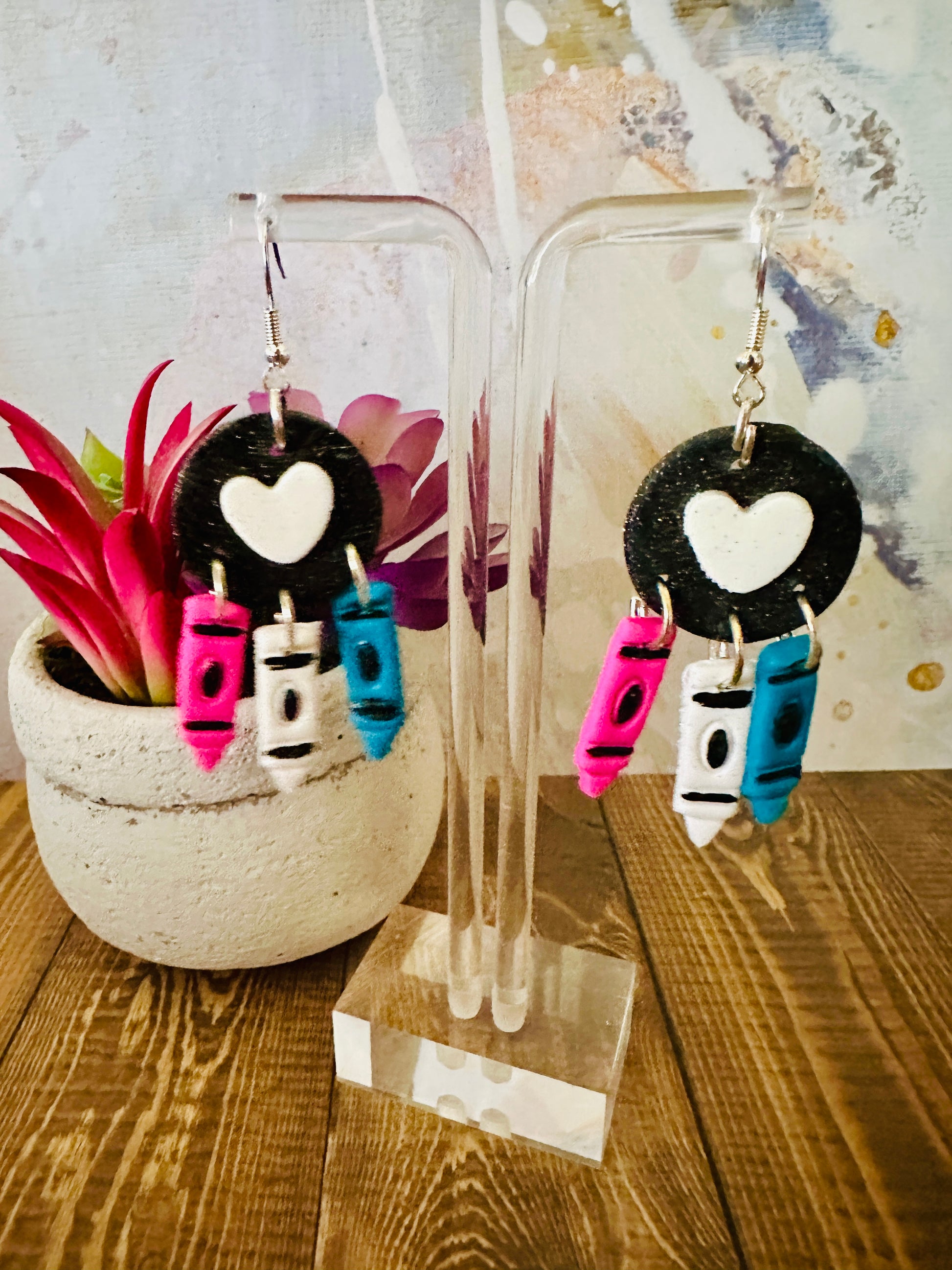 For the Love of Crayon polymer clay earrings on stand with colorful plant background, handcrafted teacher appreciation gift.