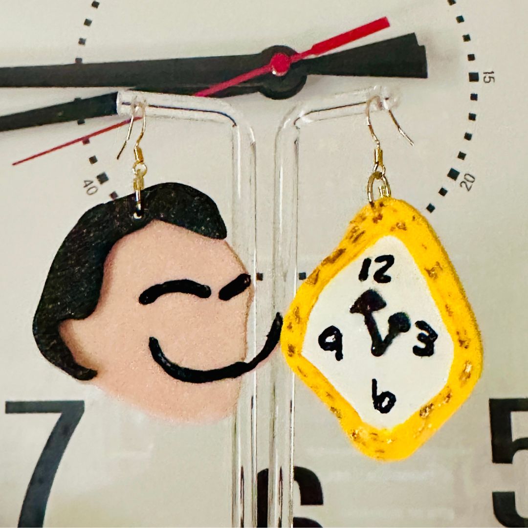 Detailed close up of large Dali earrings showing black hair with a long handpainted mustache and handpainted melted clock with an actual clock backdrop.