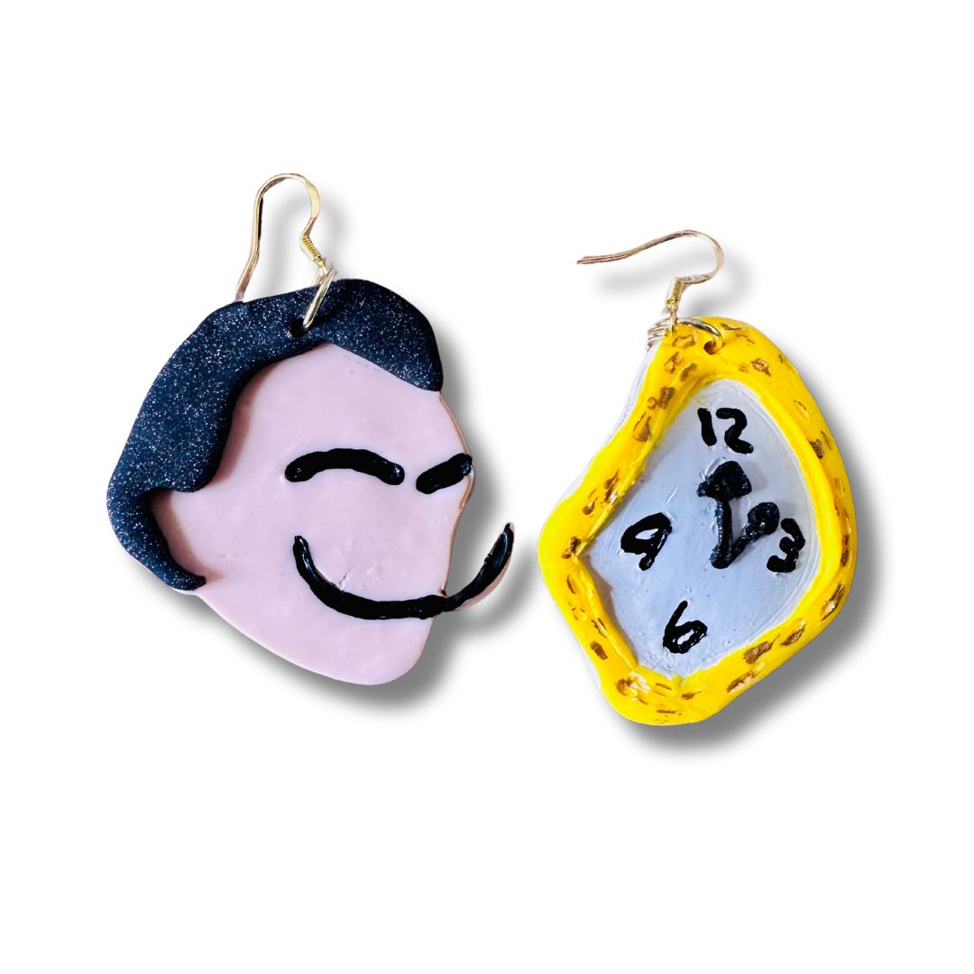 A pair of handmade Dali earrings on a white background. Left is Dali's silhouette and on the left is a representation of the melted clock with yellow handpainted outer trim, black numbers and arrows, and in a bent shape.