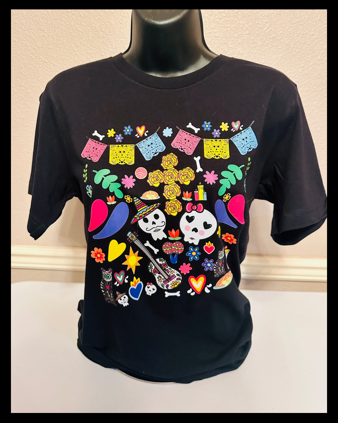 Hand designed Dia de los Muertos t-shirt displayed on mannequin showing fit and design placement.