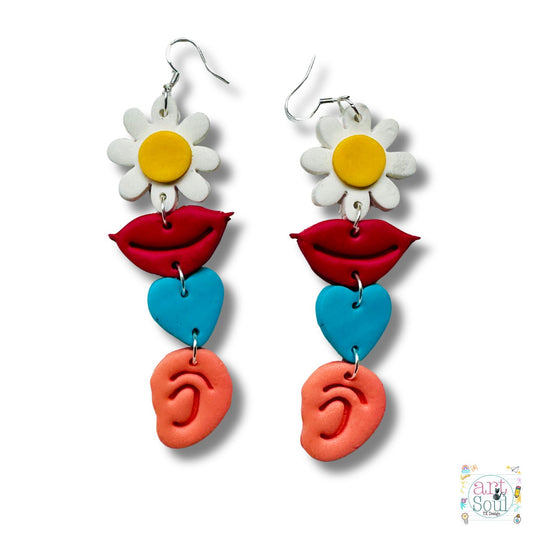Colorful earrings with floral, lip, heart, and ear designs on a white background.