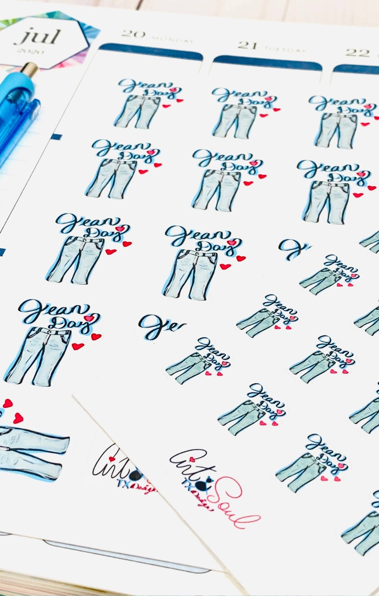 Multiple Jean Day planner sticker sheets laying in open teacher planner from angled view