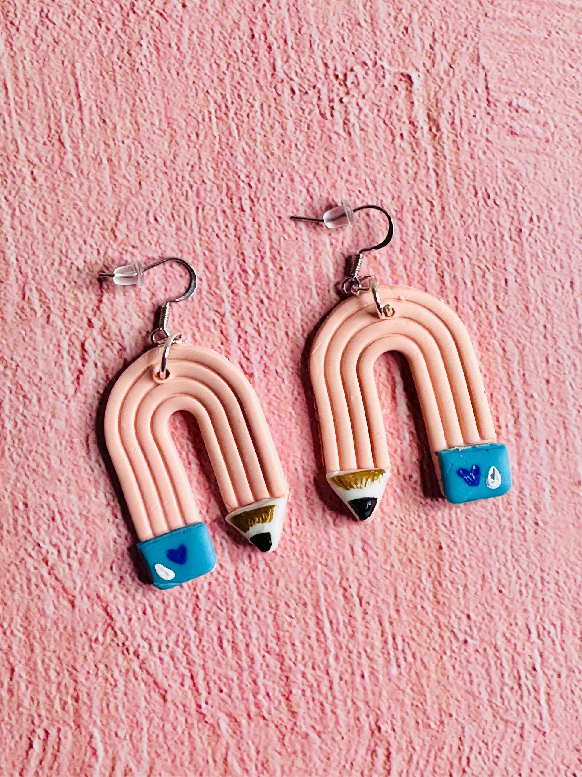A close up of the Pink Pencil Teacher Earrings.  Each pencil is pink with a blue eraser.