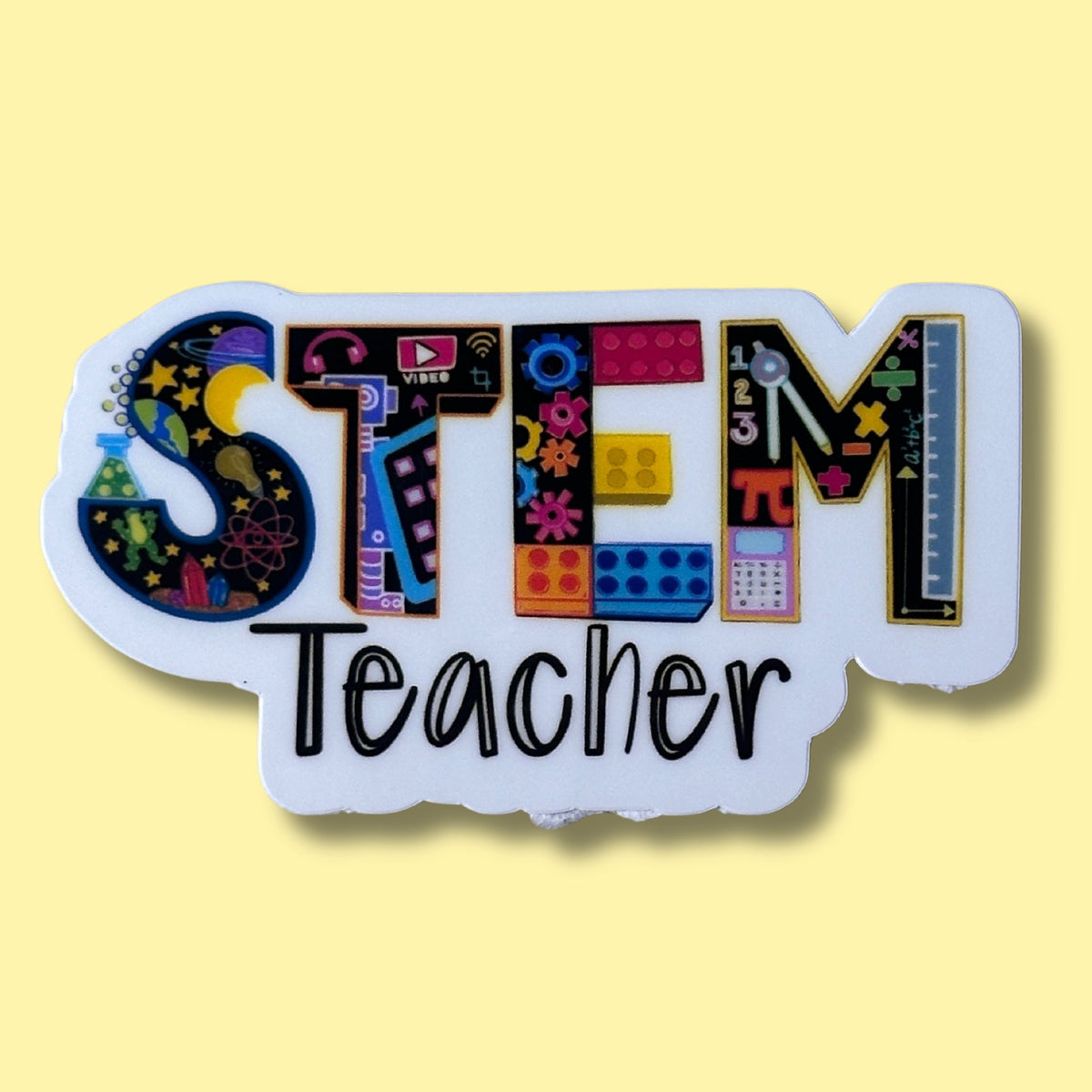 A white die-cut sticker or plaque featuring the word 'STEM' in colorful educational-themed lettering and the word 'Teacher' below in black script, shown on a pale yellow background.