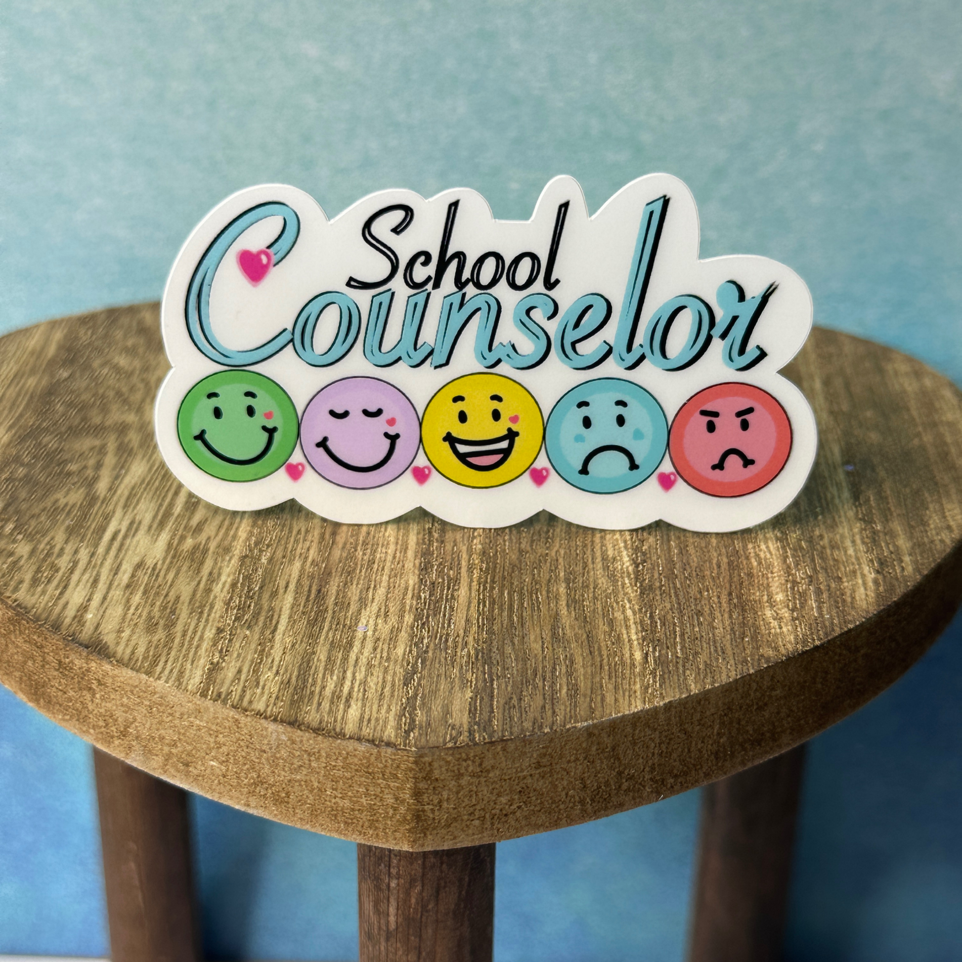 School Counselor waterproof vinyl sticker displayed on a wooden table in front of a blue wall.