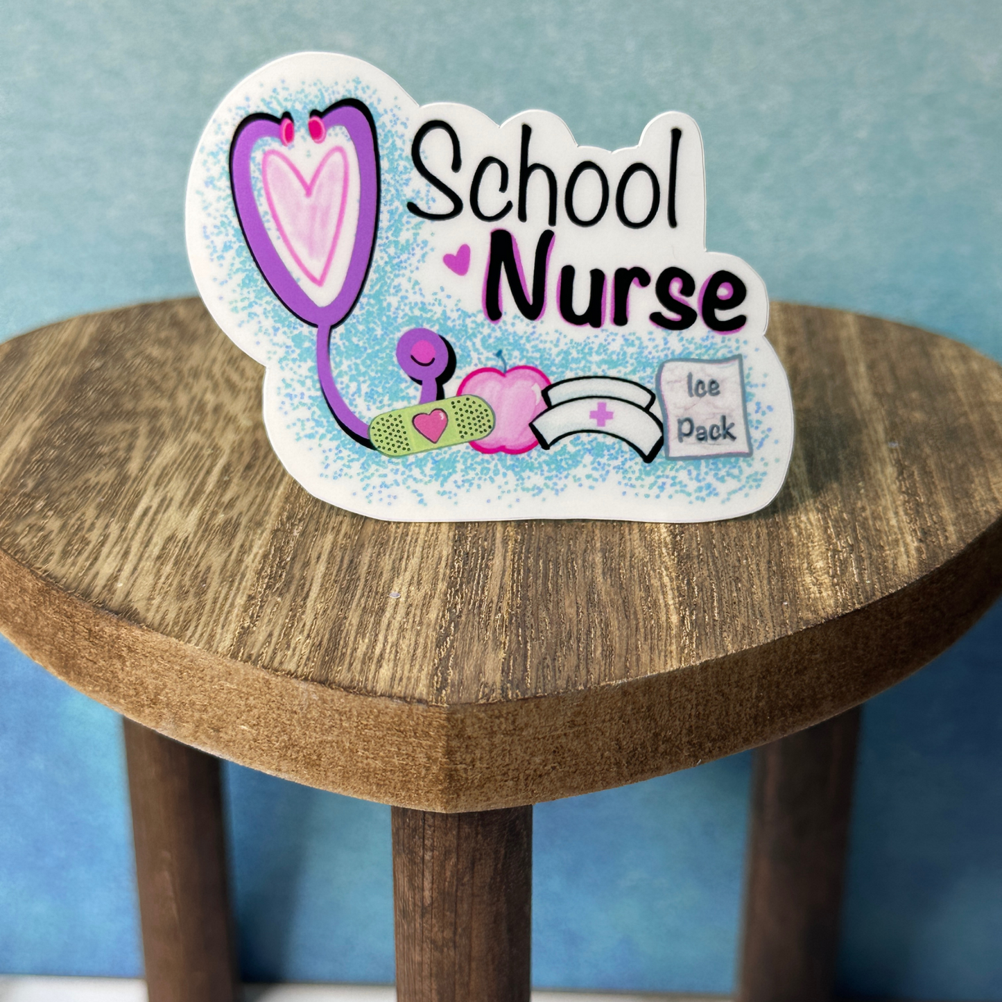 School Nurse waterproof vinyl sticker displayed on a wooden table in front of a blue wall.