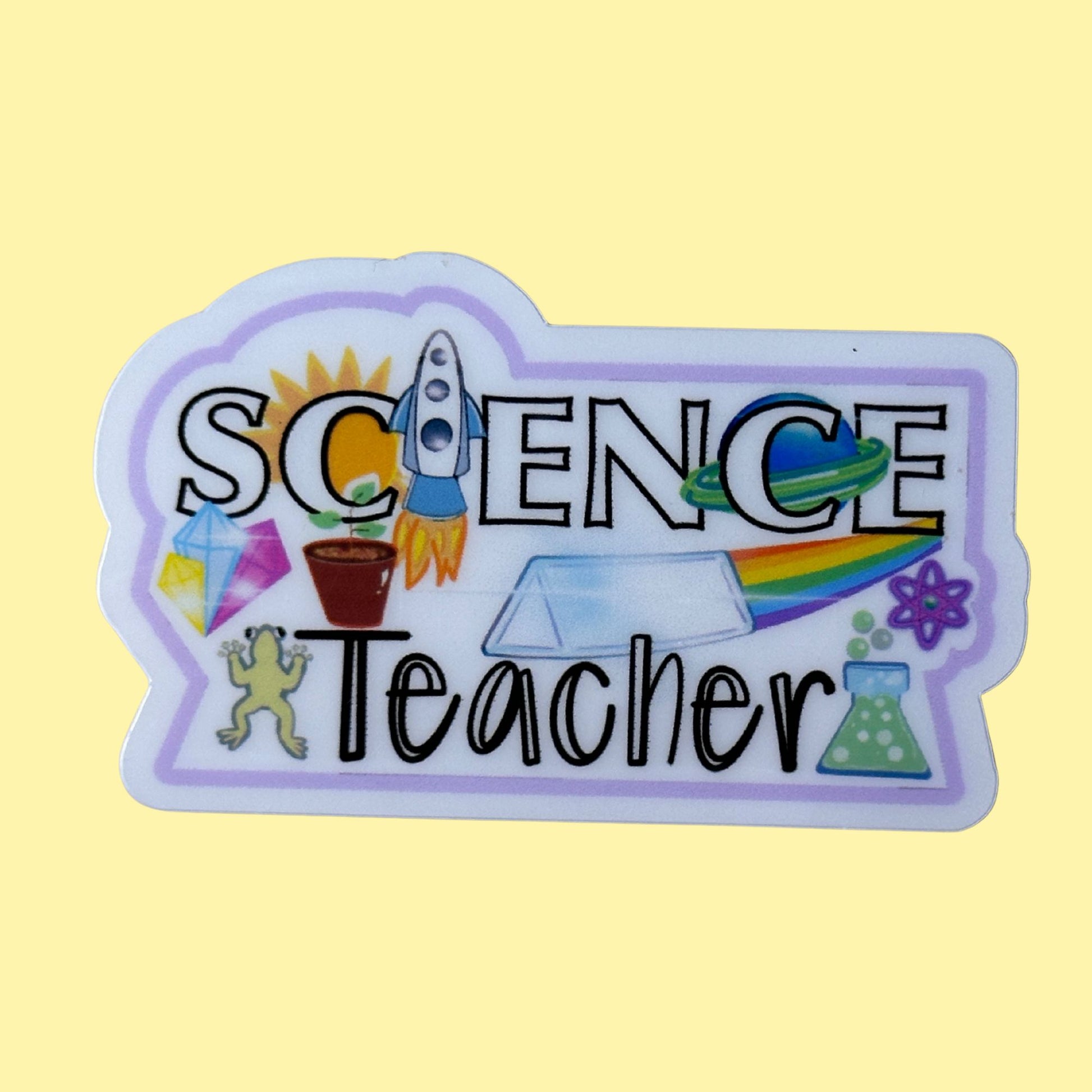A die-cut sticker with the words 'SCIENCE Teacher' in black lettering, decorated with colorful science-themed illustrations including a rocket ship, crystal, plant, rainbow, and beaker, shown on a pale yellow background.