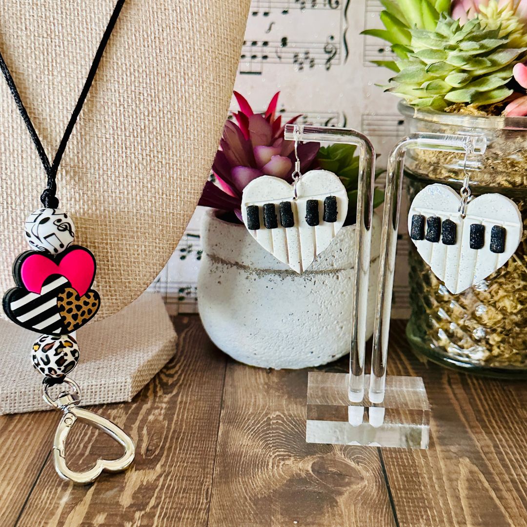 Heart-shaped jewelry on a wooden surface with a plant and music sheet in the background