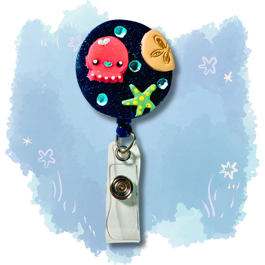 Colorful handmade polymer clay badge reel featuring ocean-themed designs of starfish, sand dollar, and octopus, perfect for teachers and healthcare workers to display ID badges