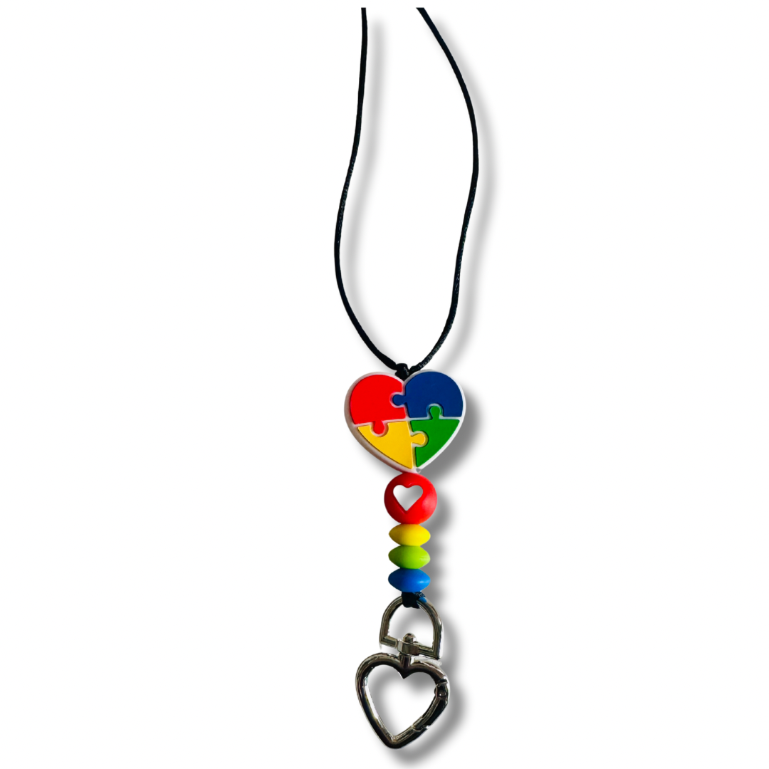 Puzzle Heart Autism Awareness Lanyard black nylon string version with colorful puzzle piece heart pendant on white background.