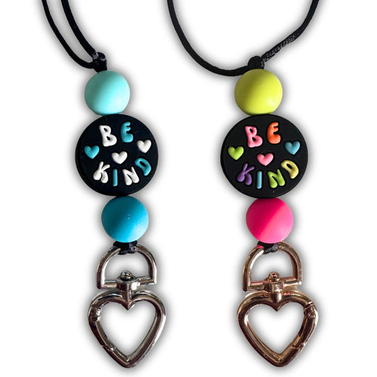 Close-up of Be Kind teacher lanyard showing both blue and rainbow variant beads with heart-shaped clasp on white background