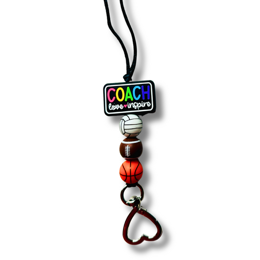 Lanyard with sports-themed beads and 'COACH' tag on a white background