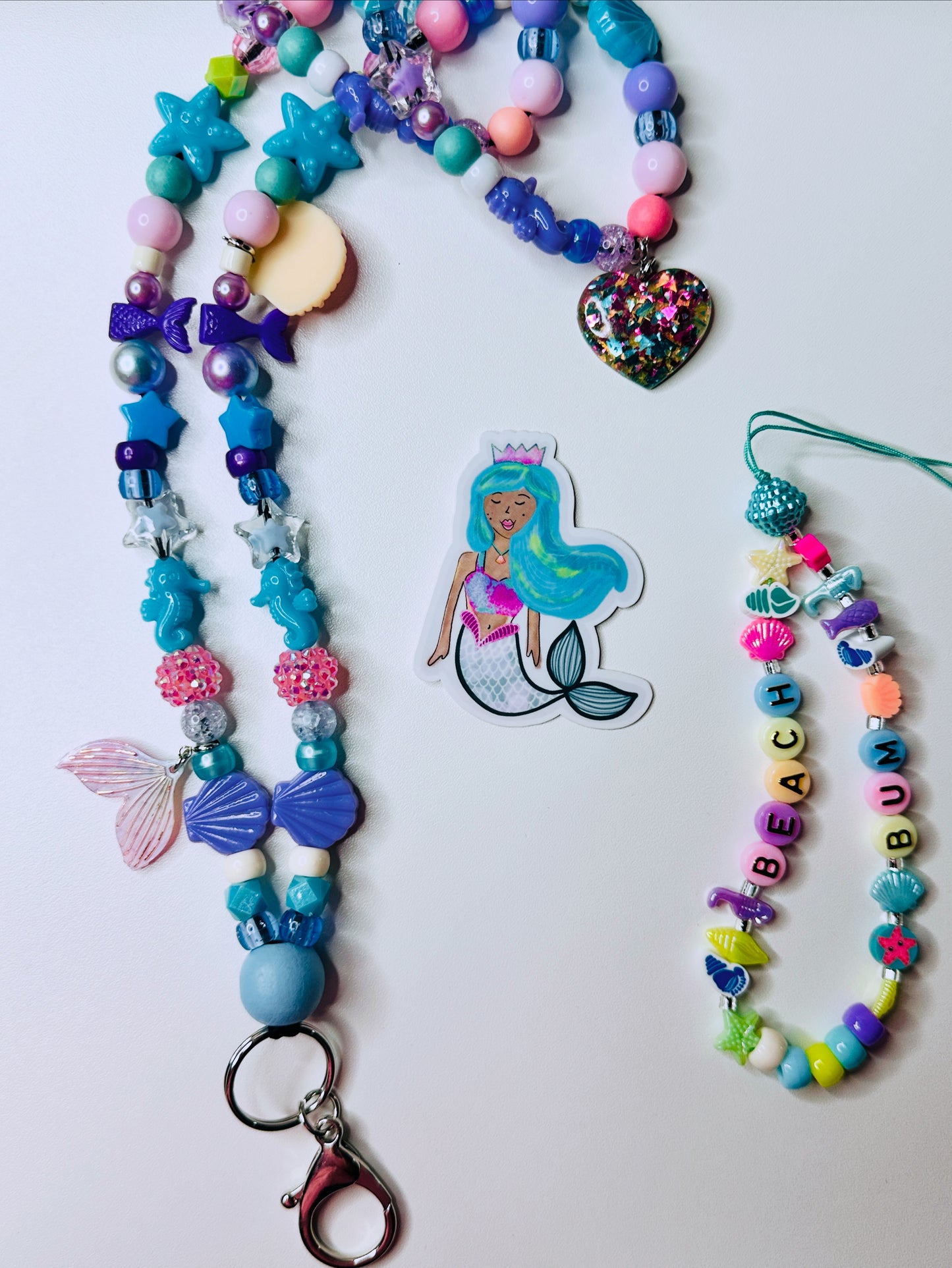 Mermaid teacher lanyard with wooden bead, beach bum phone charm, and waterproof sticker on white background.