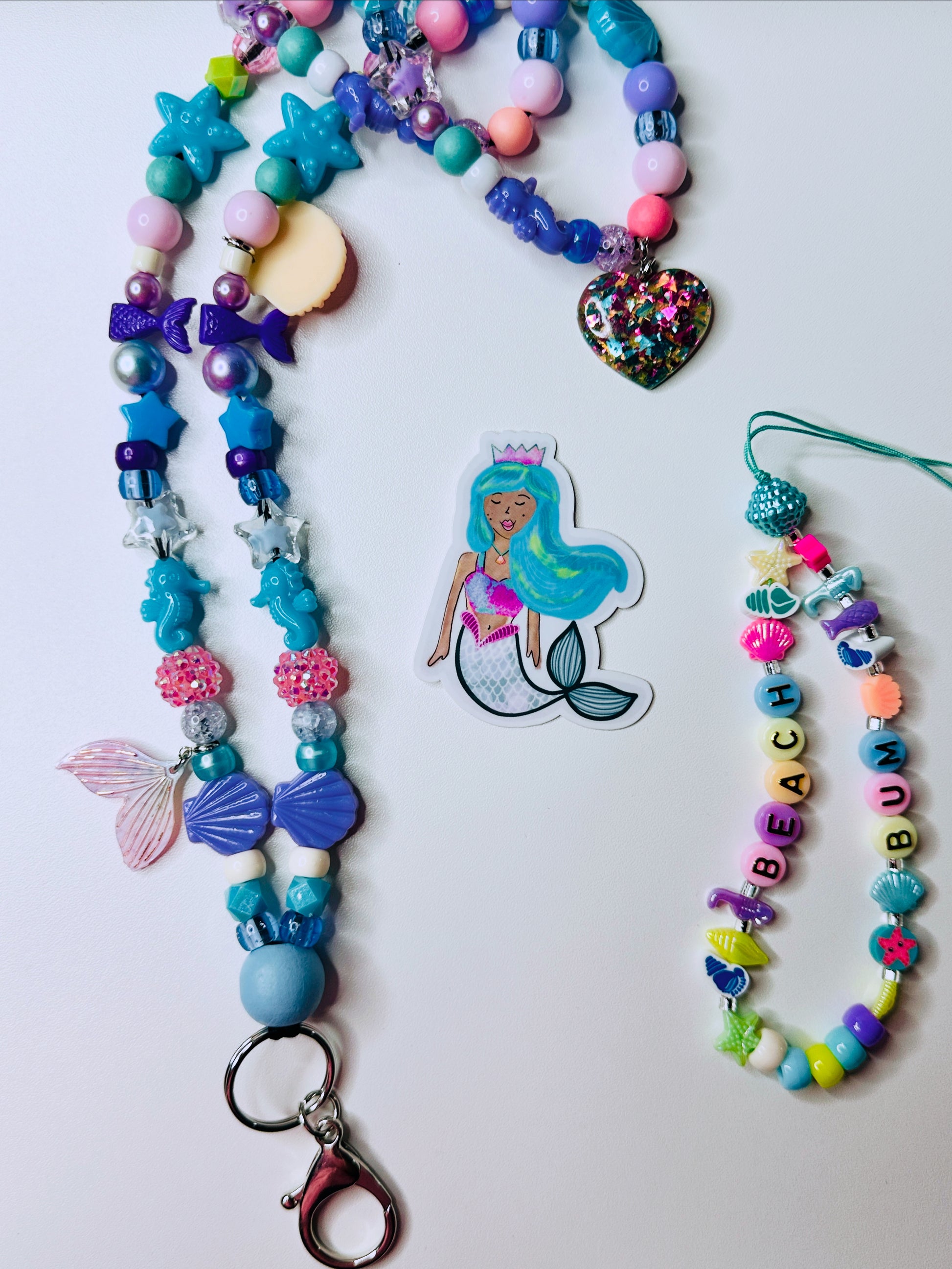 Mermaid teacher lanyard with wooden bead, beach bum phone charm, and waterproof sticker on white background.