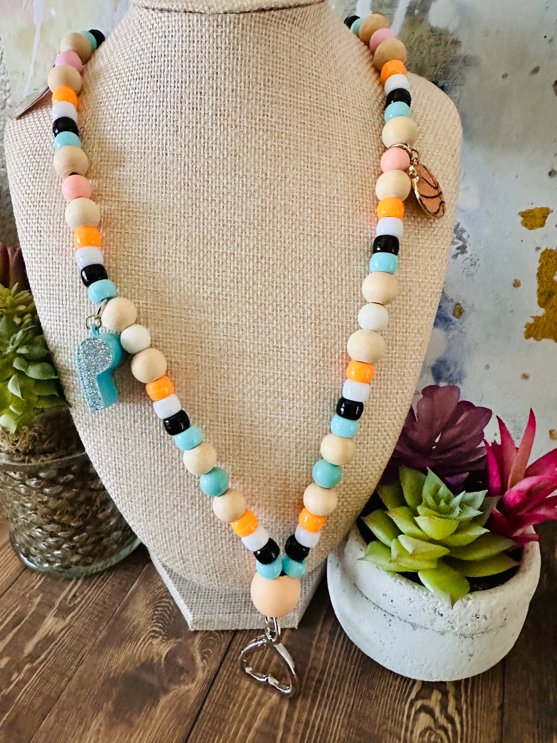 P.E. coach beaded lanyard whistle basketball charms on mannequin with succulent background