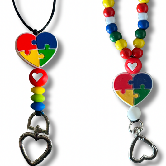 Two colorful beaded lanyards with heart-shaped autism awareness charm on a white background. One on the left without colorful wooden beads and the other on right filled with beads.