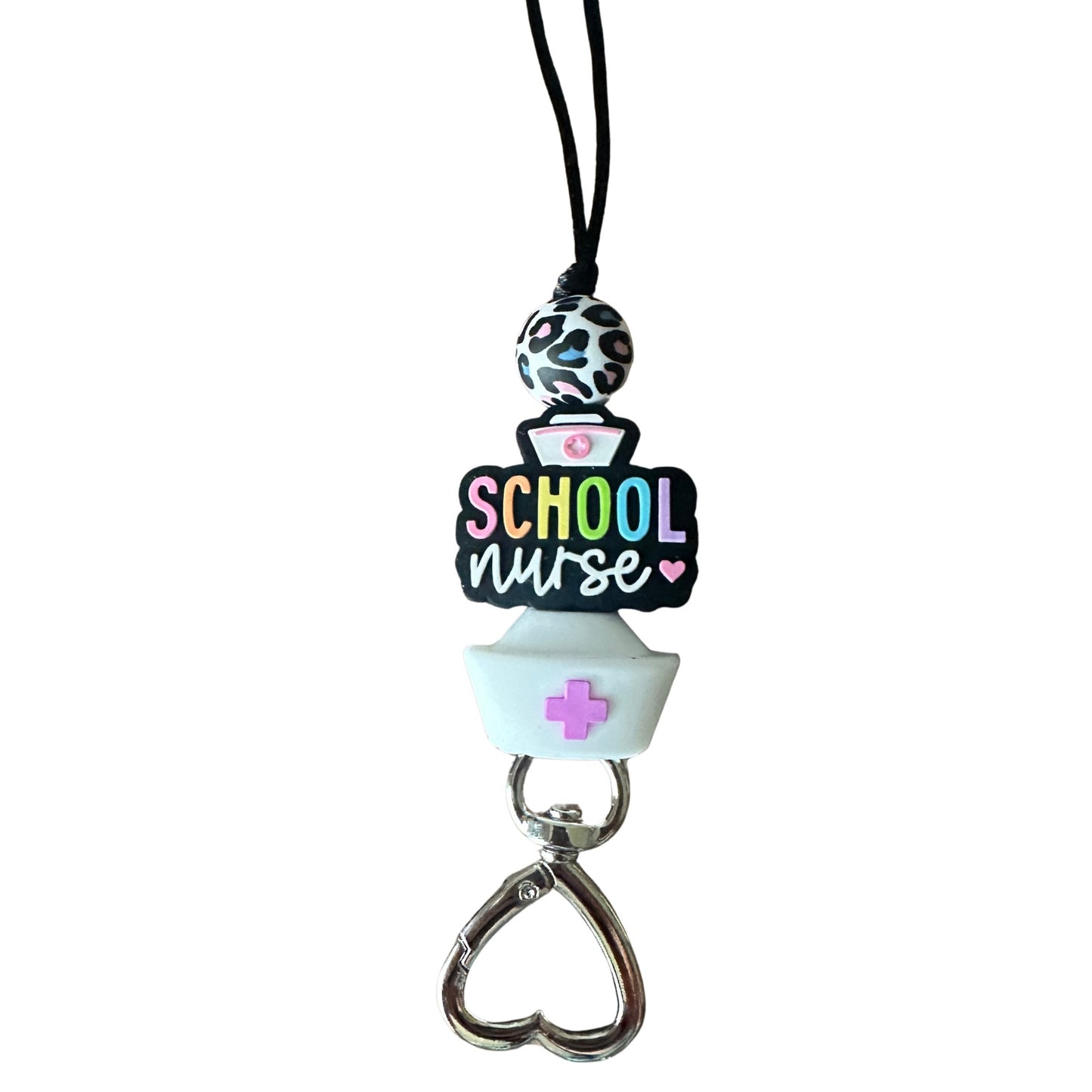 Close-up of School Nurse silicone beads in rainbow letters and heart-shaped metal clasp on white background.