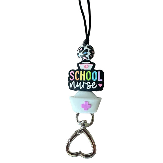 Close-up of School Nurse silicone beads in rainbow letters and heart-shaped metal clasp on white background.
