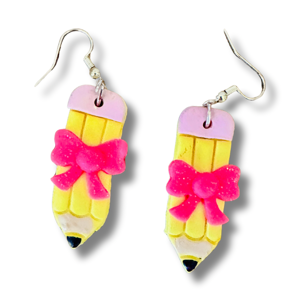 Close-up of straight polymer clay pencil earring with pink bow and sterling silver hook on white background